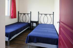 een kamer met 2 bedden en een rode deur bij Résidence Serias - 3 Pièces pour 6 Personnes 484 in Germ