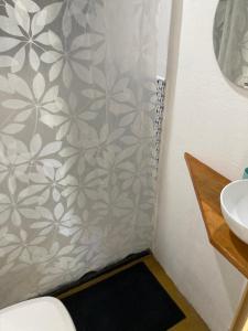 a bathroom with a shower curtain and a sink at Caju com Mel in Moreré