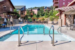 una piscina en un complejo con mesas y sillas en Southern Comfort Lodge-in Pigeon Forge, sleeps 18-7BR 6BA luxury cabin, w FREE attraction ticket!, en Pigeon Forge