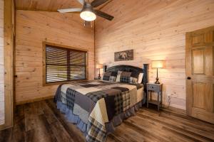 Un dormitorio con una cama y un ventilador de techo. en Southern Comfort Lodge-in Pigeon Forge, sleeps 18-7BR 6BA luxury cabin, w FREE attraction ticket!, en Pigeon Forge 35 fotos más