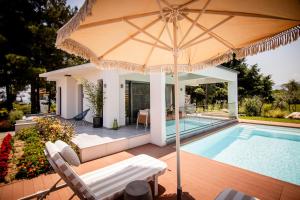 a house with a swimming pool and an umbrella at 4 Roses Pool Villas in Litochoro