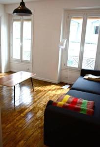 een woonkamer met een bank en een tafel bij Beautiful 1 bedroom in Le Marais in Parijs