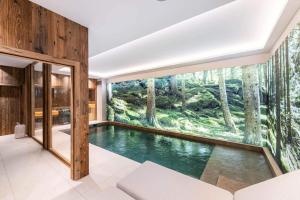 - une piscine dans une maison avec une grande fenêtre dans l'établissement Résidence Bois Du Ban - Chalets pour 10 Personnes 764, à le Praz