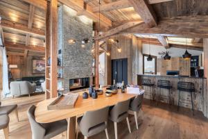 a kitchen and dining room with a wooden table and chairs at Résidence Bois Du Ban - Chalets pour 10 Personnes 764 in le Praz