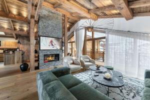 a living room with a couch and a fireplace at Résidence Bois Du Ban - Chalets pour 10 Personnes 764 in le Praz