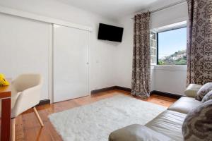 een woonkamer met een bank en een raam bij Sea La Vie Madeira in Ribeira Brava