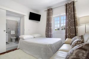a bedroom with a bed and a couch and a window at Sea La Vie House in Ribeira Brava
