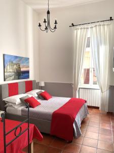 ナポリにあるResidenza Chiaiaのベッドルーム1室(赤い枕とシャンデリア付きのベッド1台付)
