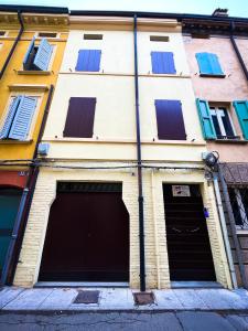 two garage doors in a building with windows at House Brennero 29 in Carpi