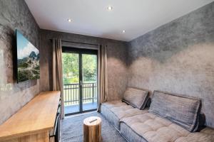 ein Wohnzimmer mit einem Sofa und einem Balkon in der Unterkunft Résidence Le Sorbier - 5 Pièces pour 6 Personnes 784 in Chamonix-Mont-Blanc