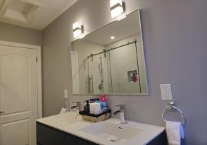 łazienka z umywalką i dużym lustrem w obiekcie Peoatas Place w mieście Oakville