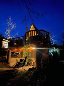 una casa con una gran terraza encima por la noche en Glamping Holiday House with hot tub and sauna- Hisa oddiha, en Smarjeske Toplice