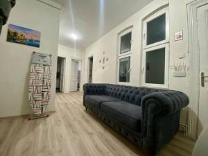 una sala de estar con un sofá negro en una habitación en Nostalgia Time Hostel, en Estambul