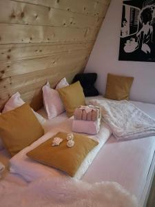 a large bed with some pillows and bows on it at Glamping Holiday House with hot tub and sauna- Hisa oddiha in Smarjeske Toplice