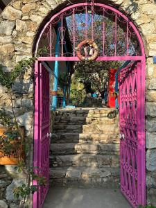 a pink door in a stone building with stairs at Eski Datça Pansiyon in Datca