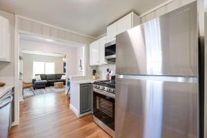 a kitchen with a stainless steel refrigerator and a living room at Fayetteville Retreat with Yard - Walk to Campus! in Fayetteville