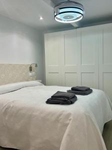 1 dormitorio con 1 cama con toallas en SANTA CLARA Con opción a Parking, en Jaén