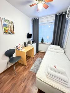 a small room with a bed and a desk at Hostelli Matkustajakoti in Kuopio