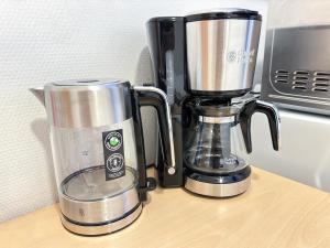 a blender sitting on a counter next to a microwave at Hostelli Matkustajakoti in Kuopio