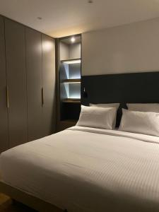 1 dormitorio con 1 cama grande con sábanas blancas en La Fleur de Sel en Honfleur