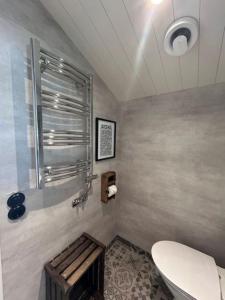 a bathroom with a toilet and a bench in it at Annas B&B in Järvsö