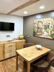 a room with a table and a painting of a gate at Pension Victoria in Halberstadt