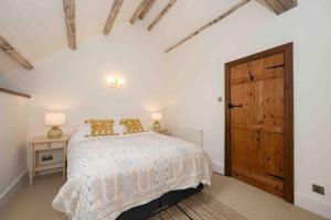 a bedroom with a bed and a wooden door at Spacious country retreat in the heart of Devon. in Crediton