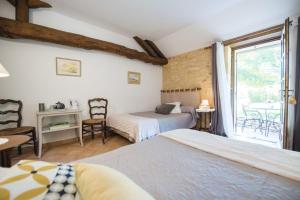 a bedroom with two beds and a window at Les Filolies in Saint-André-dʼAllas