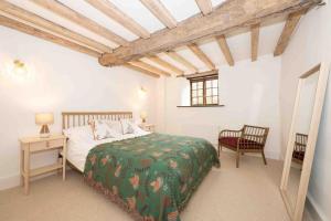 a bedroom with a bed and a table and a chair at Spacious country retreat in the heart of Devon. in Crediton