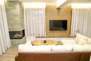 a living room with a couch and a tv at Green Villa with Private Pool in Durrës