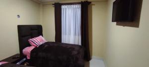 uma sala de estar com uma cadeira e uma janela em Hostal Cadena em Tupiza