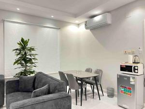 a living room with a couch and a table with chairs at APT 202 5 Twin Beds in Sulţānah