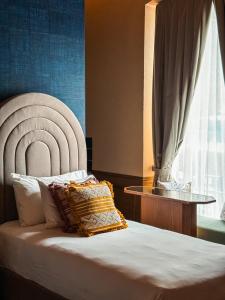 a bedroom with a bed with a chair and a window at Casa H Hotel Boutique in San Luis Potosí