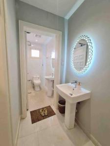 La salle de bains est pourvue d'un lavabo, de toilettes et d'un miroir. dans l'établissement APT 202 5 Twin Beds, à Sulţānah