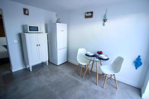 Una cocina con mesa y sillas y un refrigerador. en Apartamento Narcisa, en El Golfo
