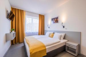 sypialnia z dużym łóżkiem i oknem w obiekcie Arrabona HotelRooms w Győr