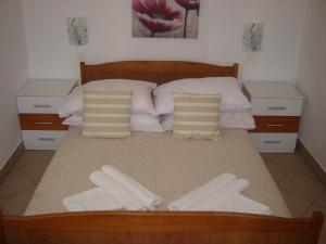 ein Bett mit zwei weißen Handtüchern darüber in der Unterkunft Apartmani Sobe KATICA in Cres