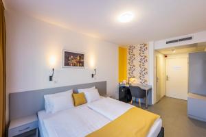 Pokój hotelowy z łóżkiem i biurkiem w obiekcie Arrabona HotelRooms w Győr