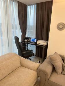 een woonkamer met een bank en een bureau met een laptop bij A very beautiful one bedroom KASS TOWERS in Accra
