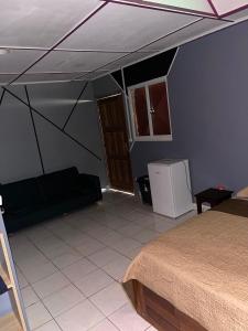 Habitación con cama y sofá en una habitación en Ouest Nelis Lodge, en Saint-Laurent-du-Maroni