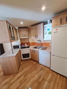 a kitchen with white appliances and wooden cabinets at Estupendo Apartamento en Madrid in Madrid