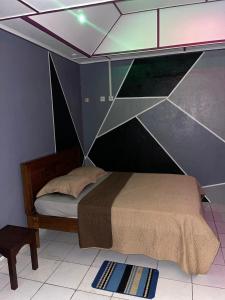 1 dormitorio con 1 cama con pared de cristal en Ouest Nelis Lodge, en Saint-Laurent-du-Maroni