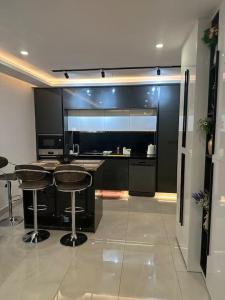 een keuken met een aanrecht en krukken in een kamer bij A very beautiful one bedroom KASS TOWERS in Accra