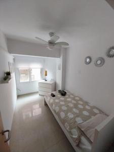 Habitación blanca con cama y tocador. en Veguita 2: piso renovado a 3 min de la playa, en Almería
