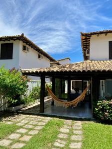 a patio with a hammock in front of a house at Praia de Geribá C 4 in Búzios
