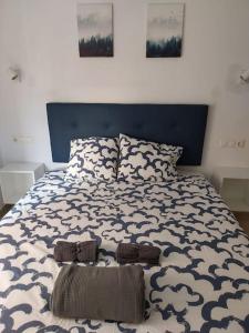 1 dormitorio con 1 cama grande y cabecero azul en Veguita 2: piso renovado a 3 min de la playa, en Almería