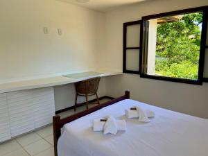 a bedroom with a bed with towels on it at Praia de Geribá C 4 in Búzios
