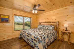 Un dormitorio con una cama y un ventilador de techo. en Happy Hideout, country livin with great mountain views, hot tub, arcades, fire pit, pets ok with fee, en Cosby