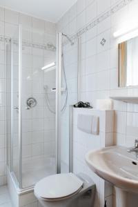 y baño con ducha, aseo y lavamanos. en Unertl Bräustüberl Gästehaus, en Haag in Oberbayern