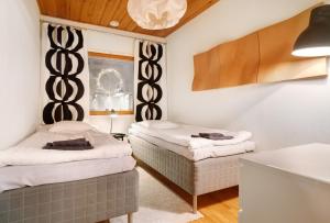 Cette chambre comprend 2 lits et une fenêtre. dans l'établissement Villa Kataja, à Rovaniemi